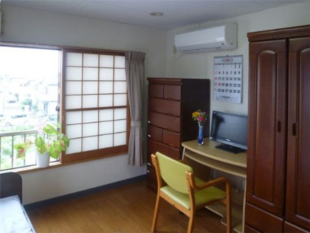 居心地の良い居室の一角 居室 ゆったりとした居室には、快適な日々を過ごすための家具が整っています。窓辺の緑や明るい陽光が心地よい空間を演出しています。