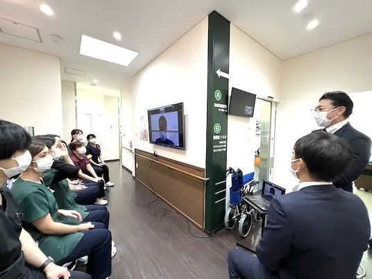 廊下で説明を聞く人々  