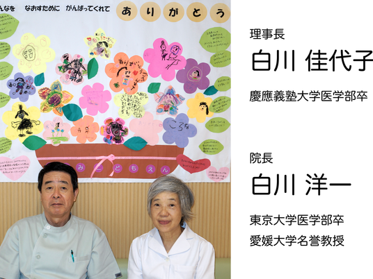 壁の掲示と職員2人  