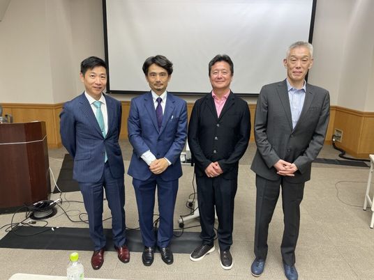 スーツ姿の男性4人の会場  