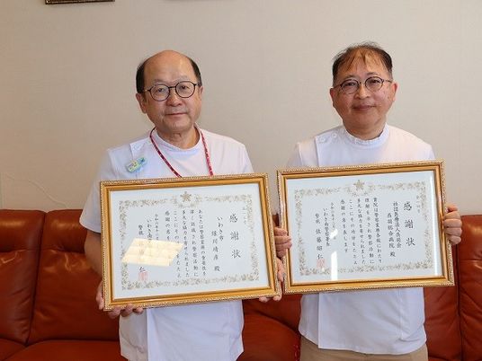 表彰状を持つ職員スタッフイメージ  