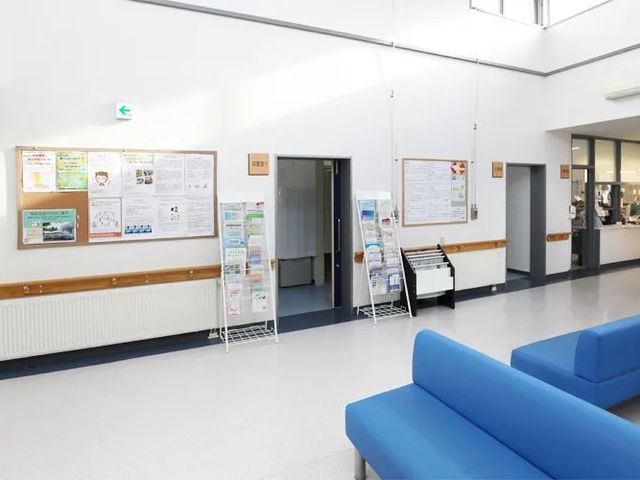 明るい廊下 廊下   高い天井と白い壁で、すっきりとした印象の廊下です。掲示物やパンフレットが並び、待ち合いにも使いやすそうです。