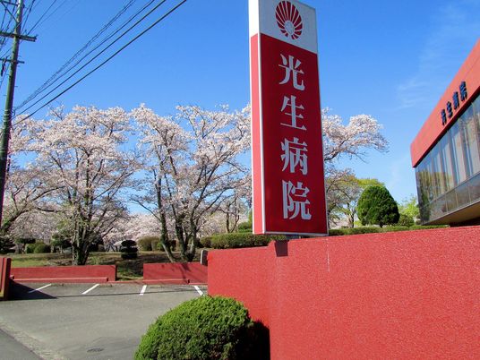 病院の看板と桜並木の外観  