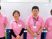 ピンク制服のスタッフとホワイトボードの前  