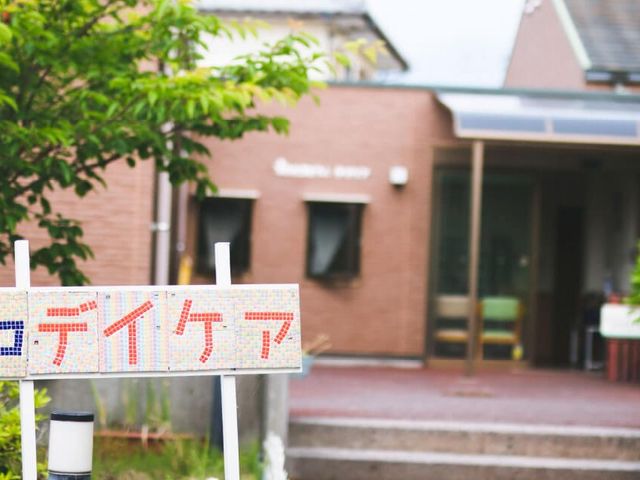 施設入口看板のある外観 外観   落ち着いた色合いの建物前に、施設名の看板が掲げられています。入口まわりはすっきりしており、来訪時の出入りがしやすそうです。