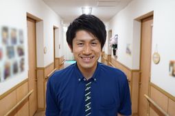 廊下に立つ笑顔の男性