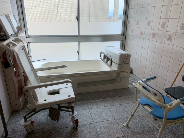浴槽と椅子のある部屋 浴室 自然光が差し込む明るい空間です。浴室内の設備は高齢者のサポートを考慮した設計になっています。