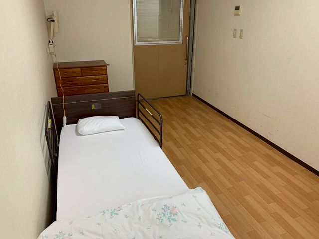 ベッドのある居室 居室 ナチュラルな色合いの床とシンプルな家具が特徴の居室です。リラックスできる空間になっています。