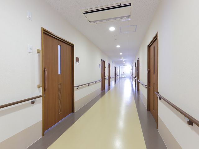 清潔感ある広々廊下 廊下 手すりがついた長く明るい廊下は、歩行に不安がある方も安心して移動できる設計です。快適な環境でのご就業をお考えの方には心強い空間となっております。