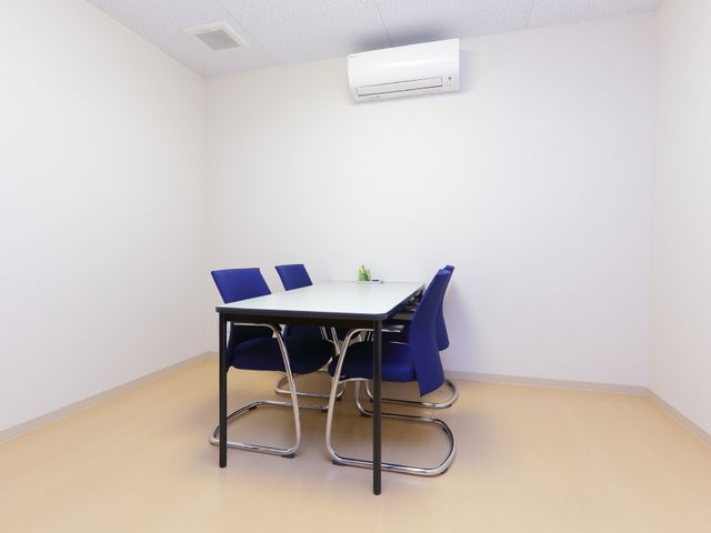 シンプルな会議テーブルセット 応接室 落ち着いた色合いの椅子とテーブルが配置された休憩室です。静かな空間でコミュニケーションを取ることができます。