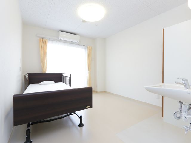 明るい清潔な居室 居室1 広々とした空間の居室は、シンプルで清潔感があります。日当たりの良い窓辺で、ゆったりとした時間を過ごせそうです。
