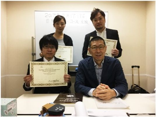 表彰状を持つ4人の会議室  