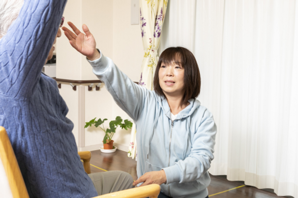 スタッフと利用者の手を合わせる様子