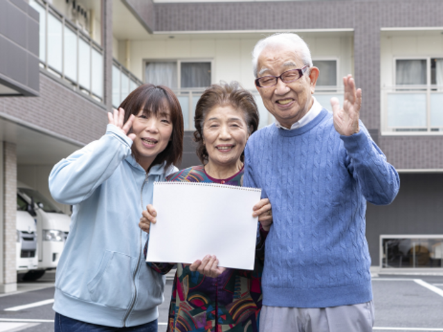 笑顔でポーズを取る三人 明るく和やかな雰囲気の職場です。スタッフと利用者様が、共に笑顔で過ごす姿が印象的です。