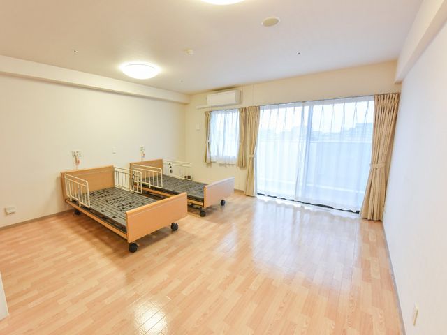 明るい居室内観 ベッド すっきりと清潔感のある居室です。大きな窓からは自然光が差し込み、心地よい空間を提供しています。