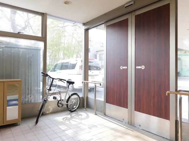 出入口と車椅子置場 玄関ポーチ ゆとりのあるエントランスは、車椅子も置けるスペースがあり、出入りしやすい造りです。太陽光が差し込む開放感のある空間でお出迎えいたします。