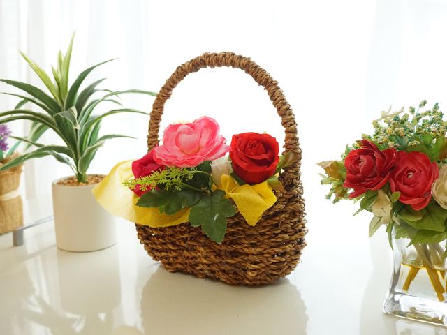 暖かい印象の花飾り 展示物 窓辺に彩り豊かな花が飾られ、訪れる人々に心地よい空間を提供しています。温もりあふれる装飾は、皆の心を穏やかにします。