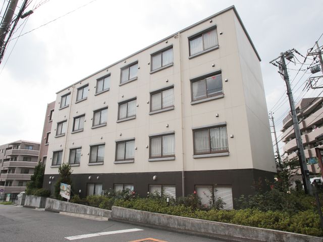 白とブラウンの建物外観 外観 清潔感ある白基調の建物で、緑豊かな立地です。