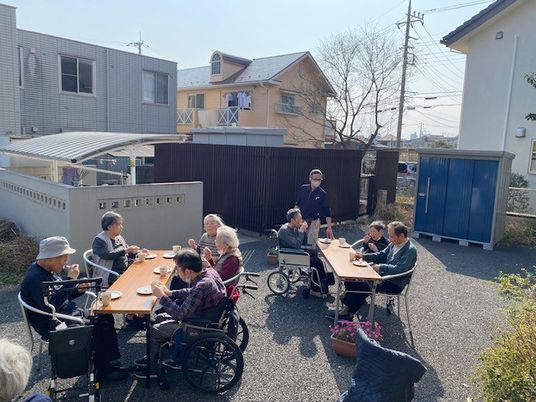 中庭で談笑する利用者と職員  
