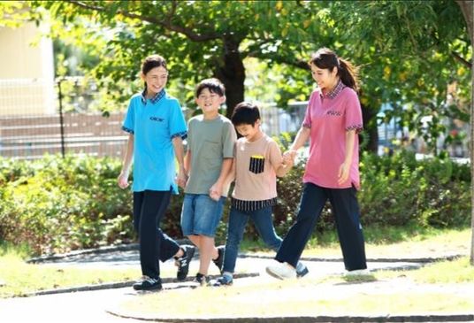 庭を歩く親子風の4人  