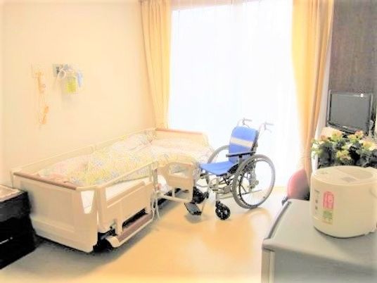 明るい個室のベッドと車椅子