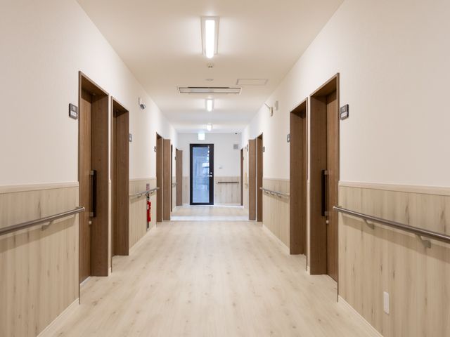 清潔で明るい廊下 廊下 明るい照明と木目調の壁が心地よい廊下です。移動がしやすい広々とした設計になっています。
