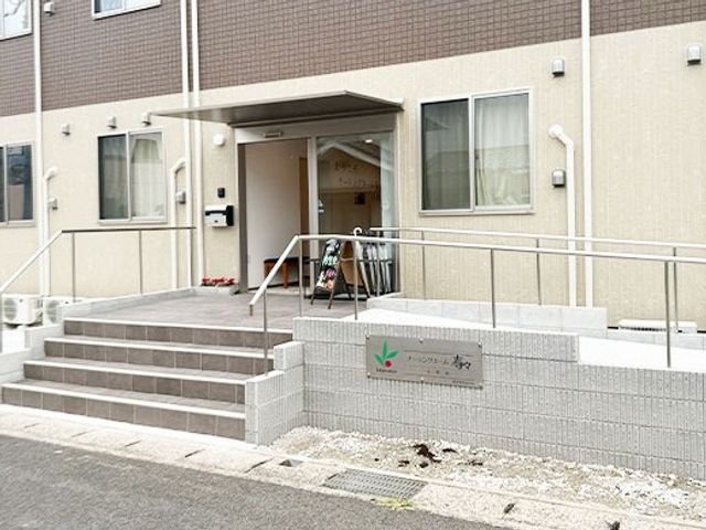 施設の正面玄関 エントランス   段差を抑えたスロープと手すりが設けられ、出入りしやすい正面玄関です。入口まわりはすっきりしていて、安心感があります。
