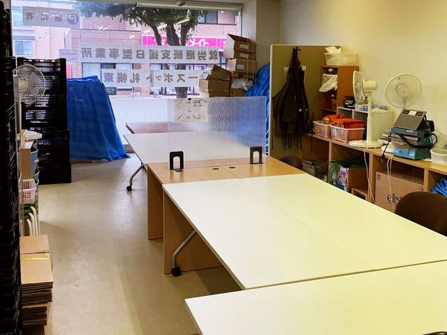 備品が並ぶ作業部屋 多目的室   広い作業机が並び、備品や箱を整理しやすい空間です。準備や片付けを行う場面が多い方に向いていそうです。