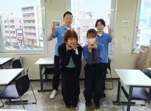 笑顔のスタッフが並ぶ多目的室