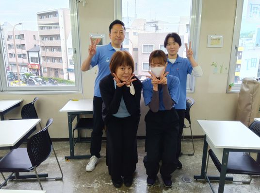 笑顔のスタッフが並ぶ多目的室