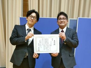 表彰状を持つ男性二人  