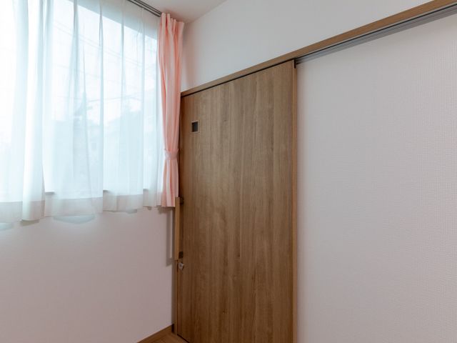 明るい居室の一角 居室   自然光が入りやすい、木目調で落ち着いた雰囲気の居室です。扉は引き戸になっており、出入りしやすい印象です。