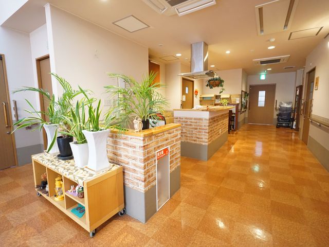 広々とした明るいロビー 廊下 温かみのある色合いのロビーは開放感があり、ゆったりとした時間を過ごすことができます。植物が彩りを添え、癒しの空間を提供しています。