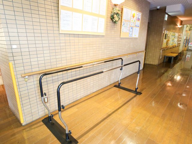 廊下に設置された手すり 歩行訓練器 安全な歩行をサポートする手すりが廊下に設置されています。明るく広い通路は快適な移動を助けます。