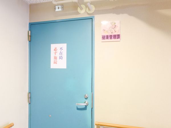 青いドアに掲示物あり