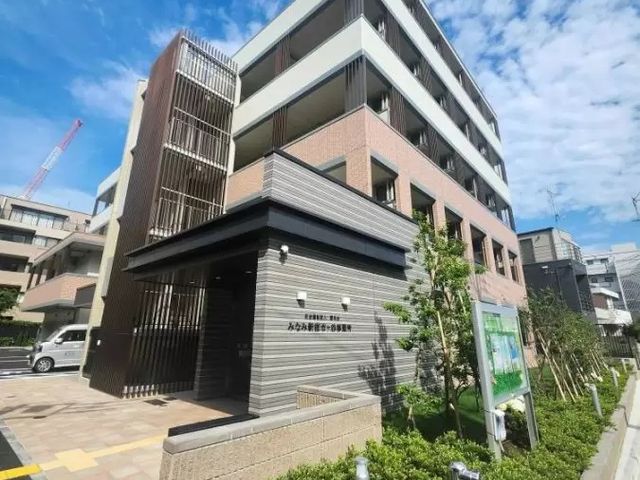 青空の下の建物外観 外観 緑豊かな庭に囲まれた建物です。快適な環境で働けます。
