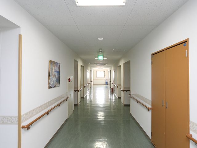 清潔な施設の廊下 廊下 手すり付きの廊下は清潔で広々としており、ゆったりと歩行できる環境が整っています。職場としての快適さを大切にしています。