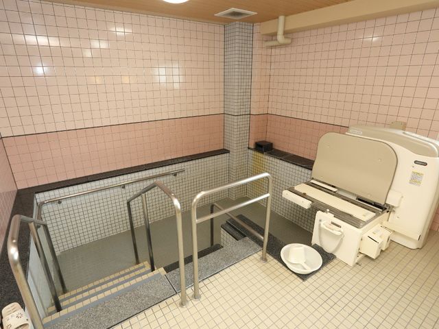 バリアフリー設計の浴室 機械浴 安全なバリアフリー設計を採用した広々とした浴室です。手すりと機械浴槽が利用者の快適な入浴を支えます。