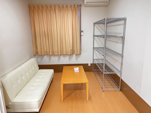 明るい休憩室のソファと棚  