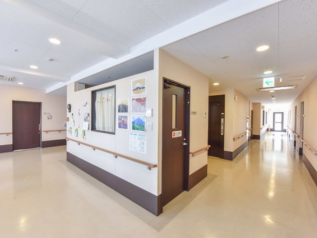 清潔な施設の廊下 廊下 ゆとりある通路が確保されたきれいな廊下です。壁には様々な掲示物や飾りがあり、温かみのある作りになっています。