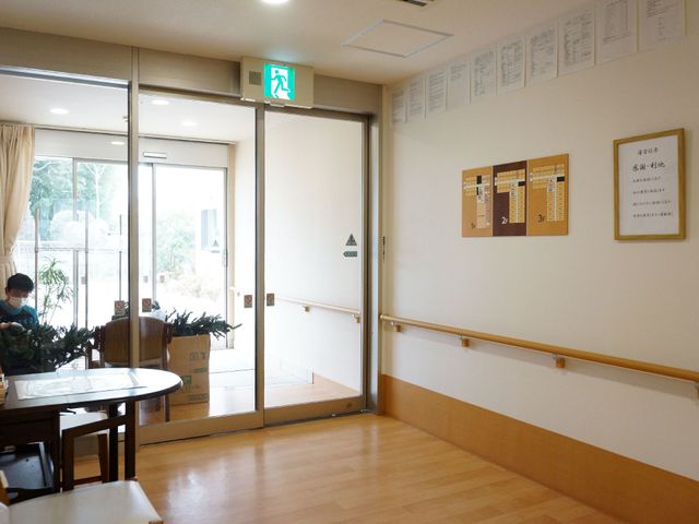 明るい待合エリア 玄関 ゆったりとした椅子が置かれたエントランスは、明るく開放感のある配置です。通路も広く、訪れる方々が快適に過ごせる設計になっています。