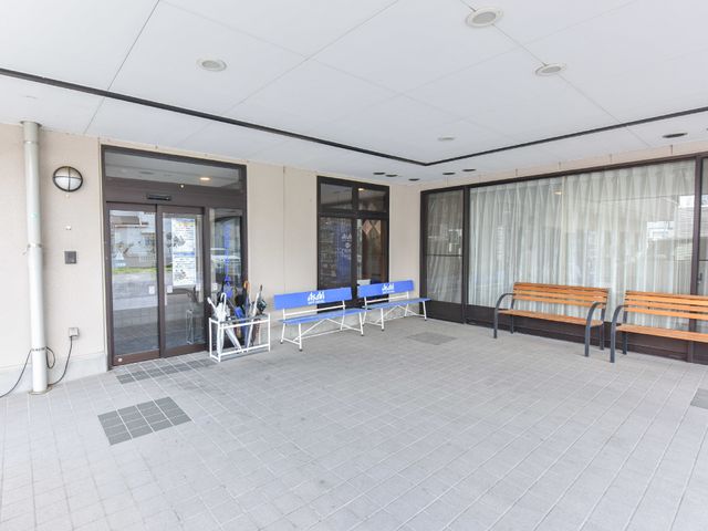 明るいエントランスの風景 エントランス ゆったりとしたベンチが設置されており、来訪者や利用者の方が待ち時間も快適に過ごせる空間です。車椅子を利用される方のためのアシスト用具もしっかりと準備されています。