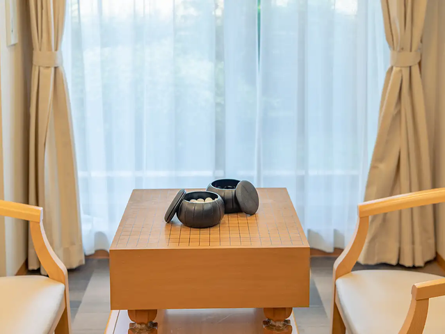 明るい日差しの外観 レクリエーション風景 1階には囲碁盤、麻雀卓などをご用意。全体でのレクリエーションの他、個人の趣味趣向に合わせた個別レクリエーション（手作りレク、カラオケ、音楽鑑賞、機能訓練体操など）に力をいれています。