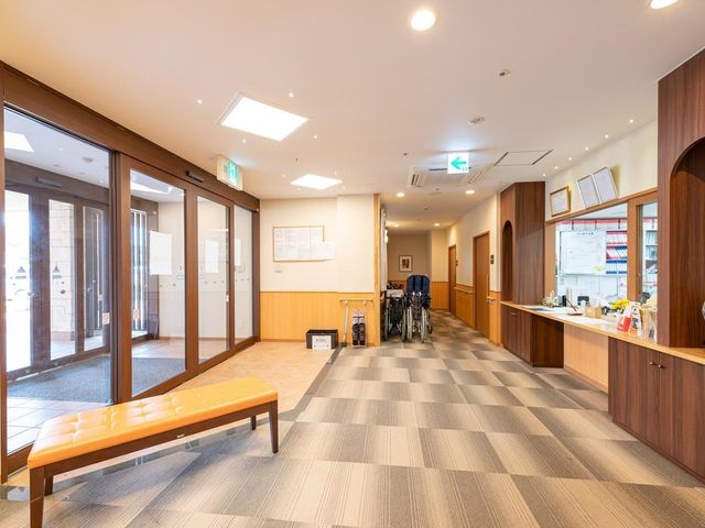 快適な共有ラウンジ エントランス 明るいエントランスには、来館者がすぐわかるよう事務室の受付があります。ご来館やお帰りの際に事務スタッフとのコミュニケーションが容易となり、ご家族様との一体的なケア提供に取り組んでおります。