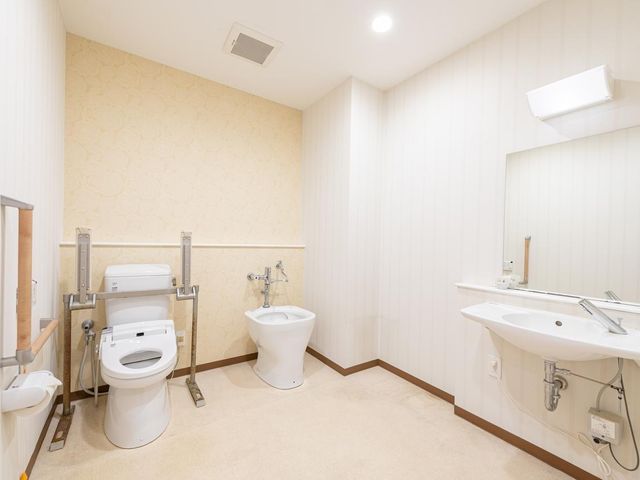 共有トイレ 共用トイレは、面会にお越しいただく方にも安心してご利用いただけます。トイレには手すりが付いており、足腰が不自由な方でも利用しやすい設計です。オストメイト対応の流しも設置しております。