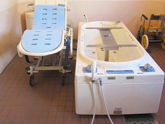 介護浴槽と移乗椅子の浴室  