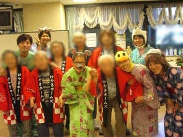 楽しそうな交流の場 多目的室 レクリエーション活動中の和気あいあいとした様子です。スタッフと利用者が笑顔で楽しんでいます。