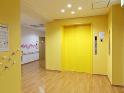 黄色い壁のエレベーターホール