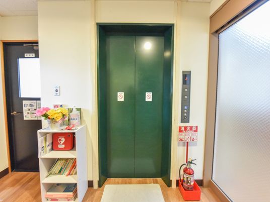 緑色の扉と書棚のあるエレベーター