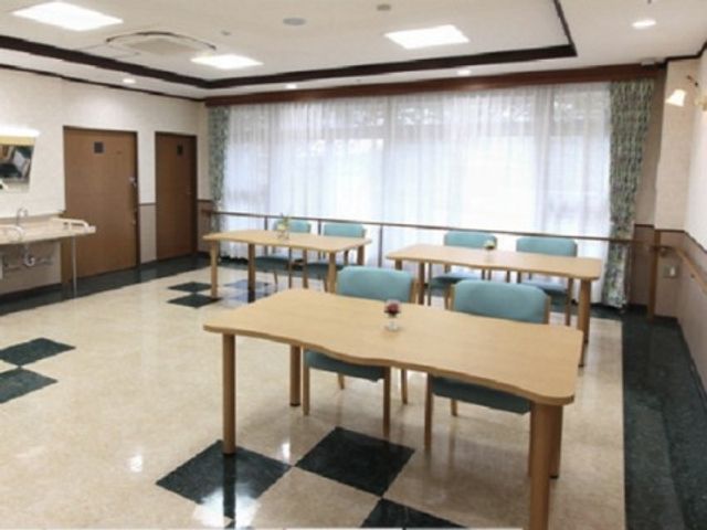 明るい空間のダイニング 談話コーナー 広々としたダイニングルームは日差しがあふれ、心地よい時間を過ごせる設計です。テーブルには花が飾られ、温かな雰囲気が漂います。